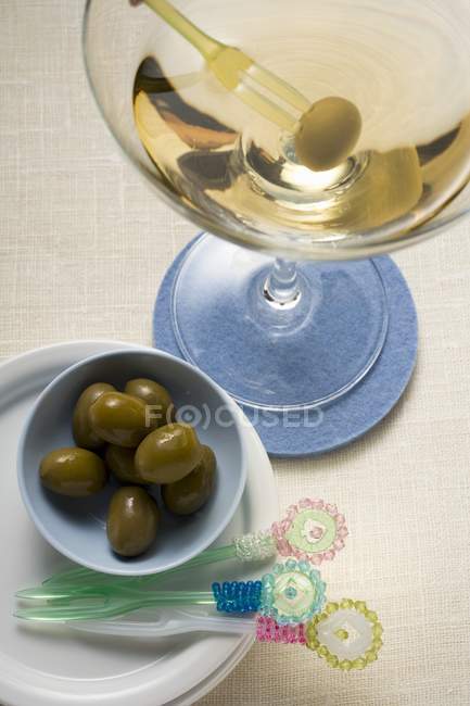 Martini and green olives on table — Stock Photo