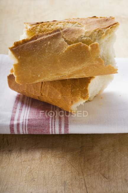 Trozos de baguette en una toalla de té - foto de stock