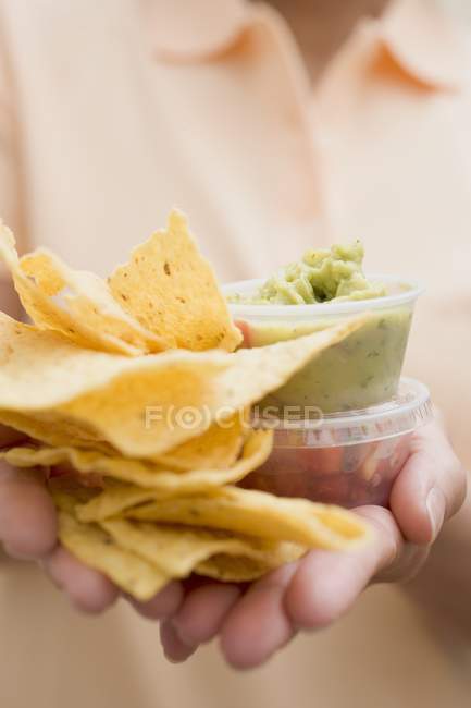 Woman holding plastic tubs of dips — Stock Photo