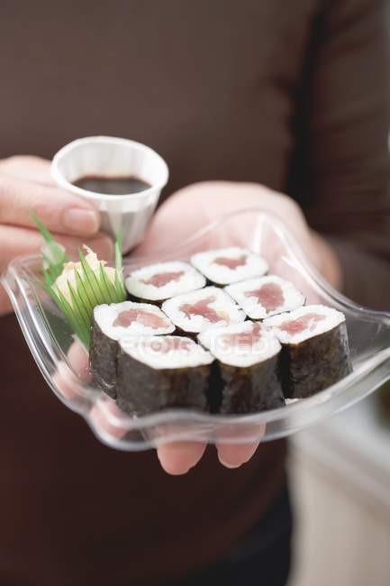 Femme tenant maki sushi — Photo de stock