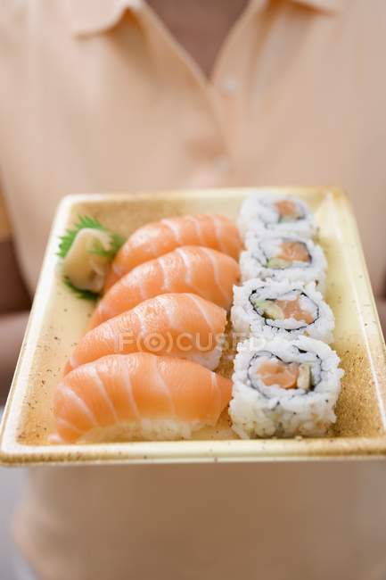 Femme tenant maki et sushi nigiri — Photo de stock