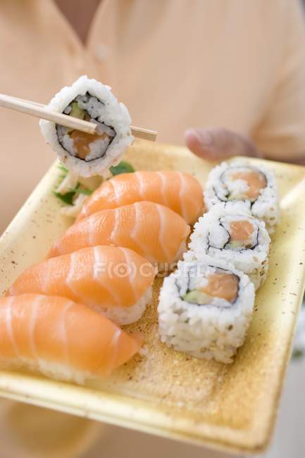 Mulher segurando maki e nigiri sushi — Fotografia de Stock