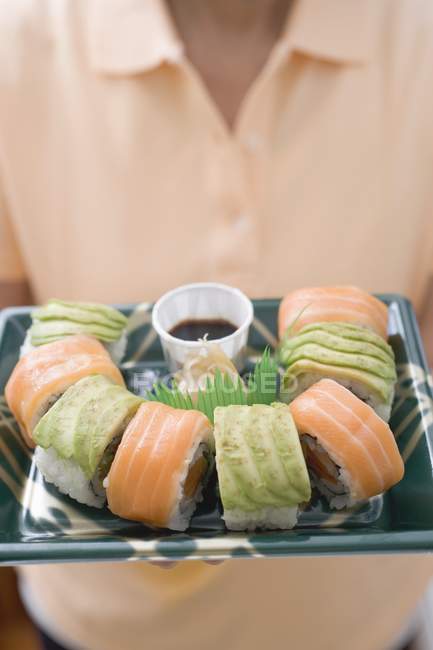 Mulher segurando maki sushi — Fotografia de Stock
