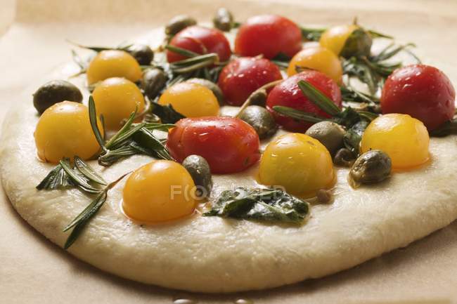 Unbaked pizza with cherry tomatoes — Stock Photo