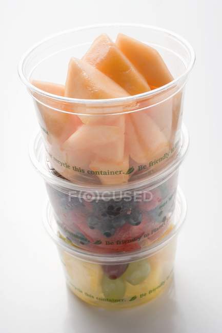 Frutas e bagas, cortadas em pedaços, frescas, em taças — Fotografia de Stock