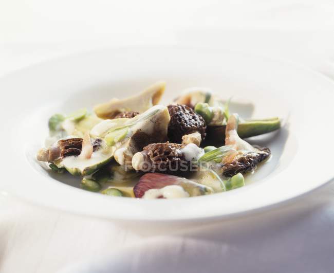 Грибы и тайские баклажаны с пенным соусом на белой тарелке — стоковое фото