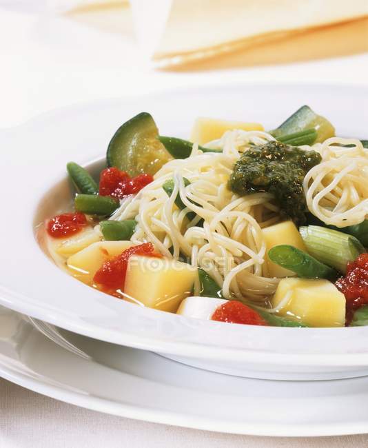 Vegetable stew with spaghetti and pesto — Stock Photo