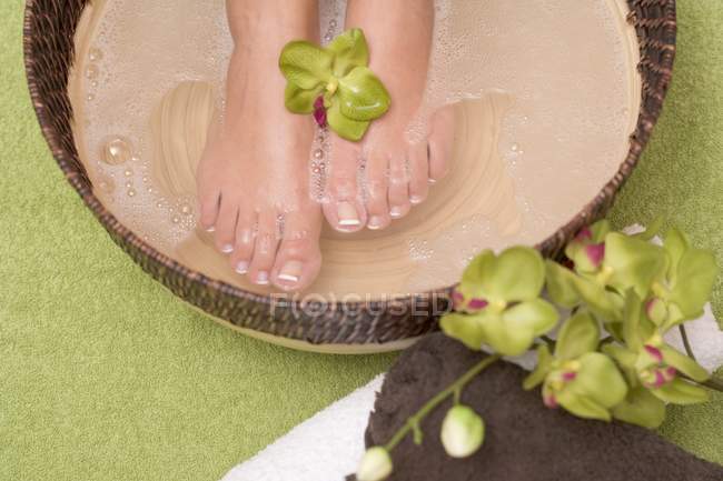 Vista elevada de los pies femeninos en un baño relajante - foto de stock