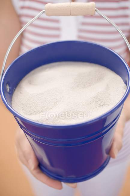Donna con secchio blu di farina in polvere — Foto stock