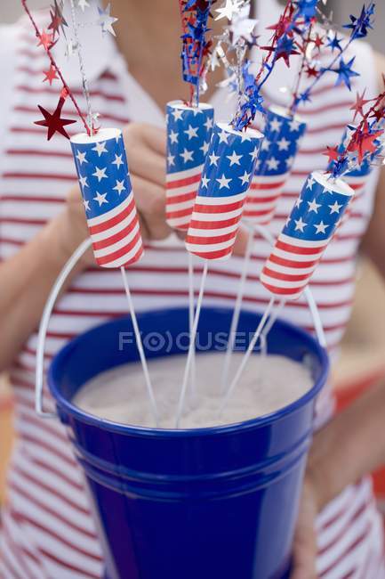 Woman holding sparklers in bucket of sand — Stock Photo