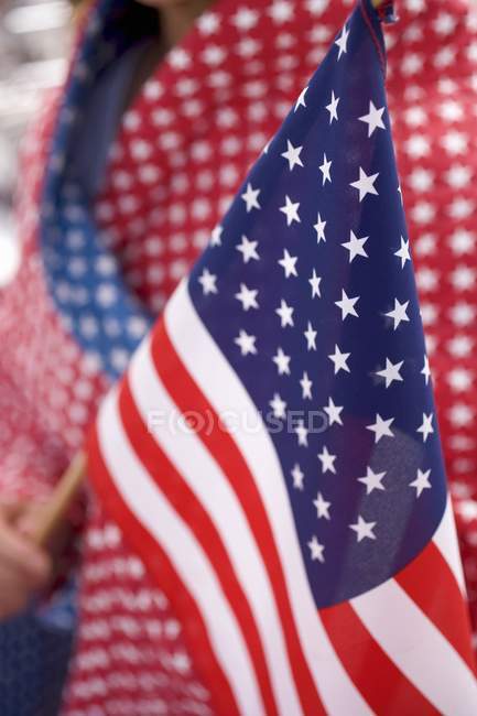 Vista recortada de la persona que sostiene la bandera estadounidense - foto de stock