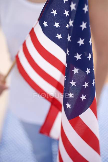 Corte close-up vista de mulher segurando bandeira americana — Fotografia de Stock