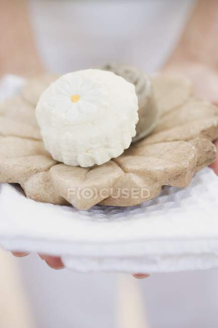 Woman holding soaps, soap dish and towel — Stock Photo