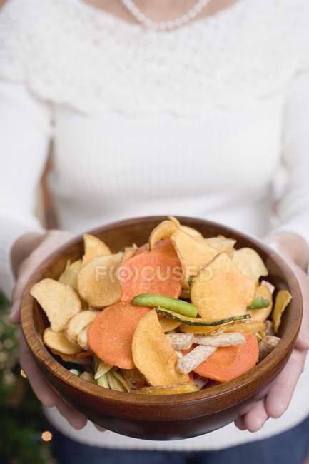 Femme tenant bol de chips — Photo de stock