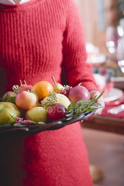 Frau hält Schale mit Früchten — Stockfoto