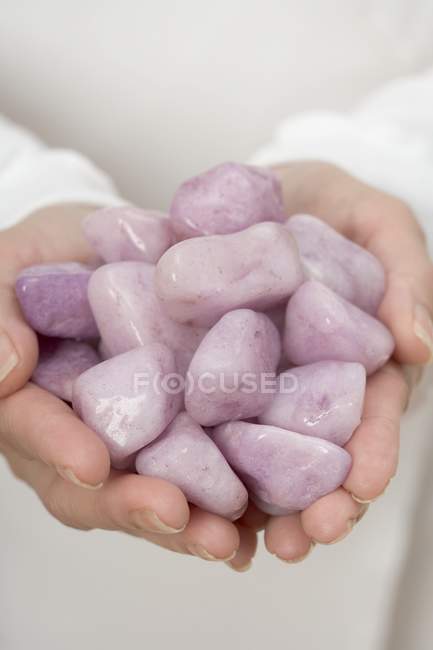 Vista de cerca de las manos sosteniendo piedras curativas - foto de stock