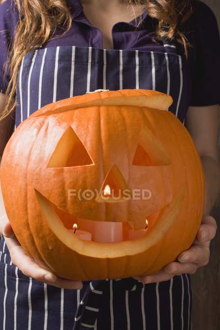 Woman holding pumpkin lantern — Stock Photo