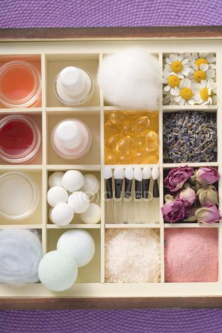 Top view of various beauty products and flowers in type case — Stock Photo
