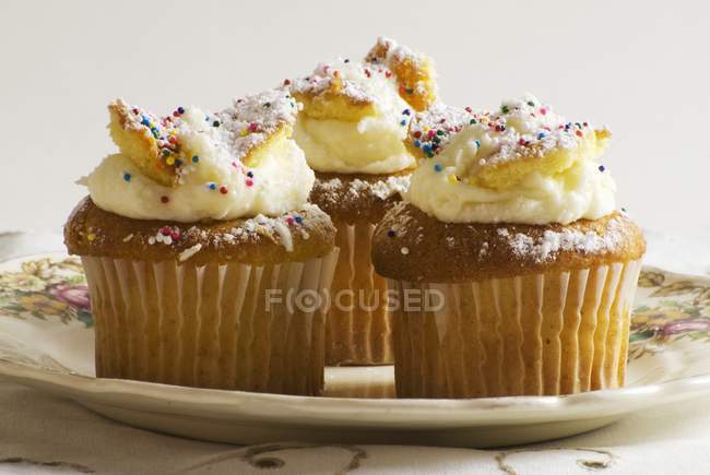 Cupcakes con aspersiones en la placa - foto de stock