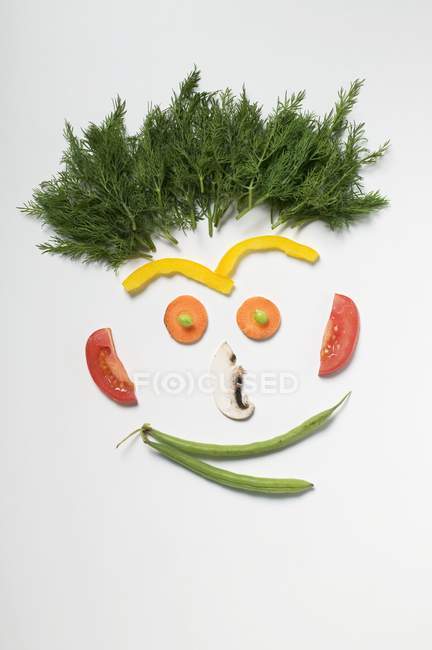 Rosto divertido feito de legumes, alecrim e cogumelo na superfície branca — Fotografia de Stock