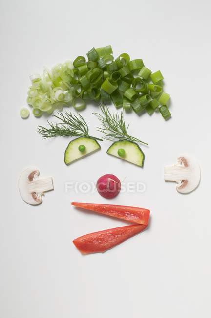 Забавні обличчя зроблено з овочів, кріп і гриби по білій поверхні — стокове фото