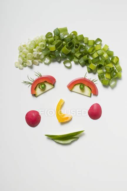 Vista dall'alto di divertente faccia vegetale su superficie bianca — Foto stock