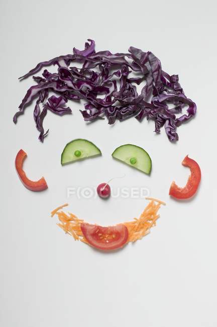 Amusing vegetable face  on white surface — Stock Photo