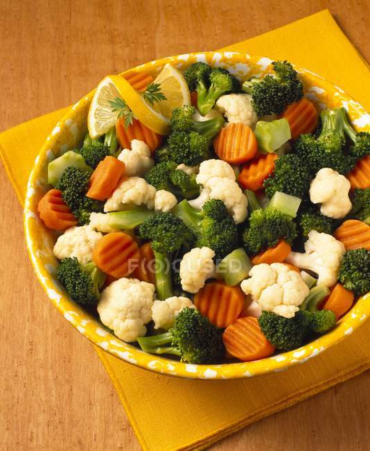 Bowl of Mixed Vegetables over yelow napkin over wooden surface — Stock Photo