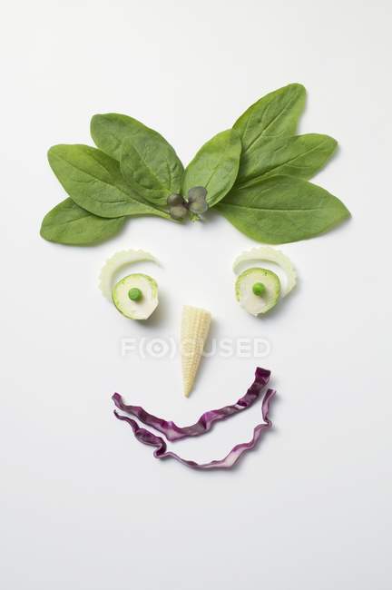 Viso vegetale con peli di spinaci su sfondo bianco — Foto stock