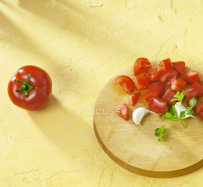 Tomates en cubitos con ajo y perejil - foto de stock