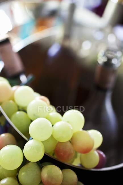 Vue rapprochée des raisins verts dans un seau à vin — Photo de stock