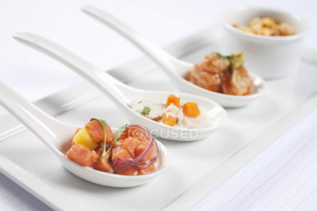 Vista close-up de três colheres de aperitivos de frutos do mar variados — Fotografia de Stock