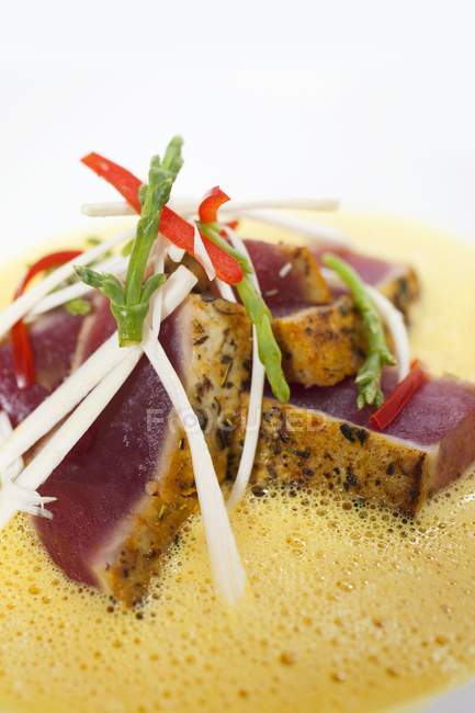 Gebratener Thunfisch mit Palmenherzen, Meeresbohnen und Hummer-Curry-Sauce auf weißem Hintergrund — Stockfoto