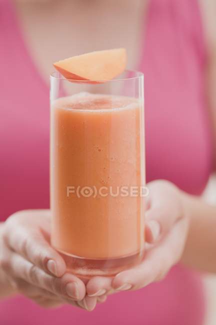 Donna che tiene un bicchiere di frullato di mango — Foto stock