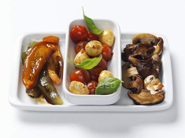 Antipasti - champignons, légumes marinés dans un bol et sur une assiette blanche — Photo de stock