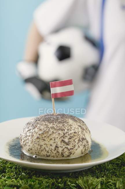 Closeup view of yeast dumpling with Austrian flag and footballer on background — Stock Photo