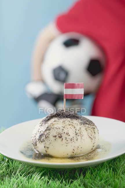 Vista close-up de bolinho de fermento com bandeira e futebolista em segundo plano — Fotografia de Stock