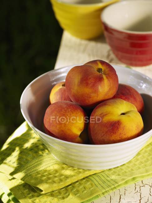 Schüssel Pfirsiche auf Handtuch — Stockfoto