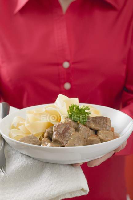 Femme tenant des filets de veau aux pâtes — Photo de stock