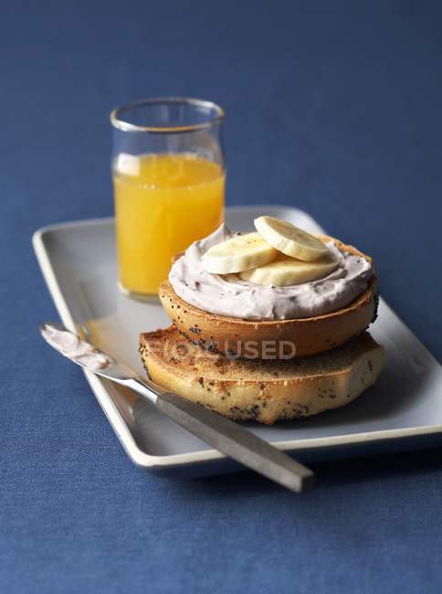 Toasted bagel and glass of orange juice — Stock Photo