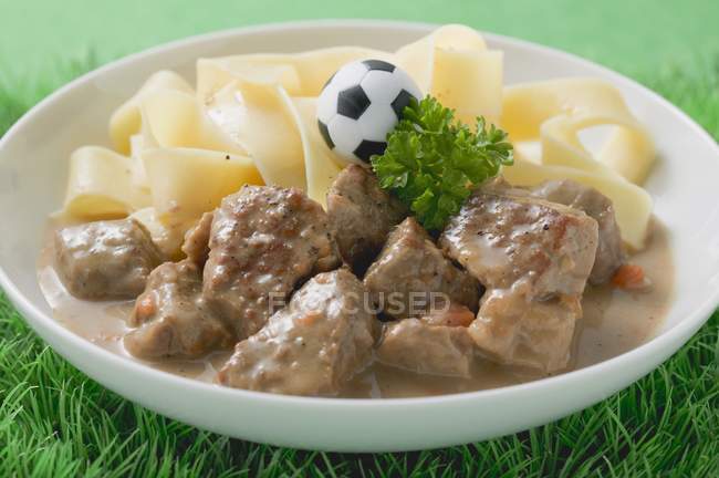 Veal fillets with pasta and football — Stock Photo