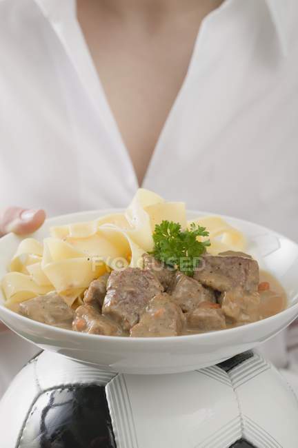 Woman holding veal fillets with pasta — Stock Photo
