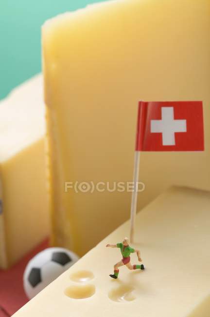 Swiss cheese with football figure — Stock Photo