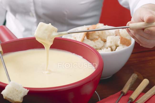 Mujer comiendo fondue de queso - foto de stock
