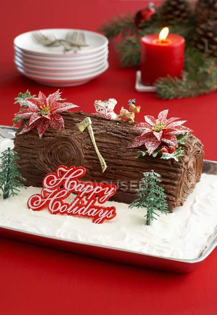 Closeup view of chocolate Yule Log with Happy Holidays sign — Stock Photo
