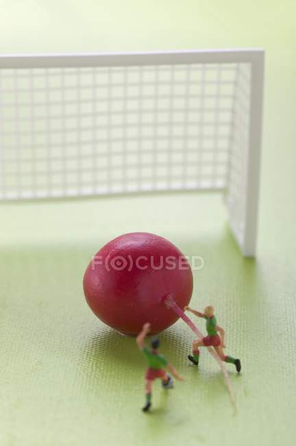 Toy footballers with radish — Stock Photo