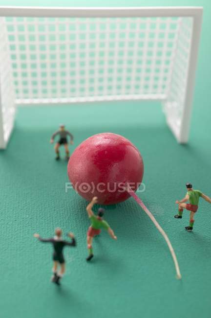Toy footballers with radish — Stock Photo