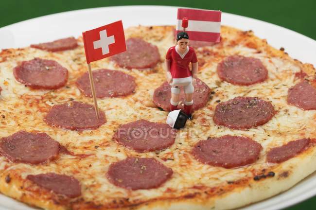 Salami pizza with footballer — Stock Photo
