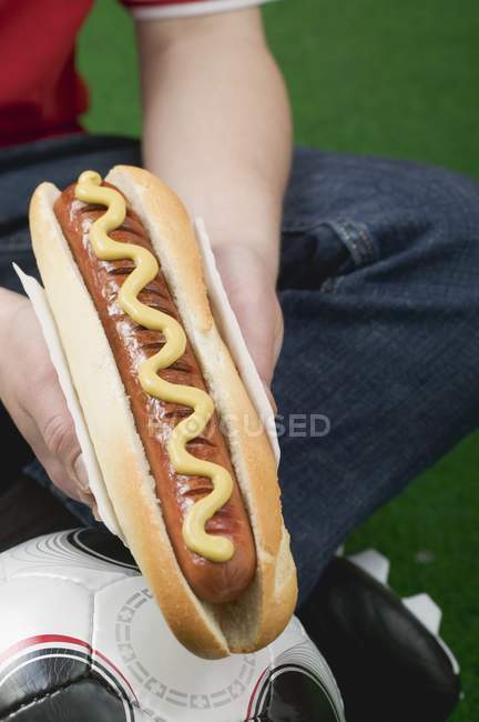 Futbolista sosteniendo hot dog - foto de stock