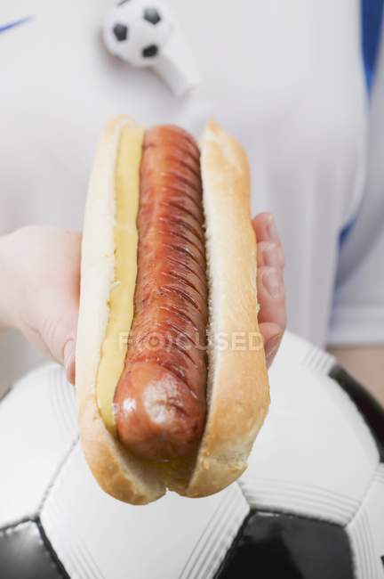 Footballer holding hot dog — Stock Photo